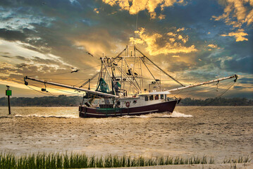 Naklejka premium A shrimp boat entering Charleston, SC harbor in the evening.