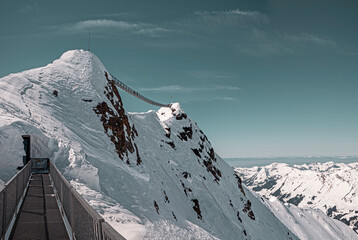A suspended peak to peak bridge. Beautiful snow covered winter alpine scenery. Snow and ice on the...