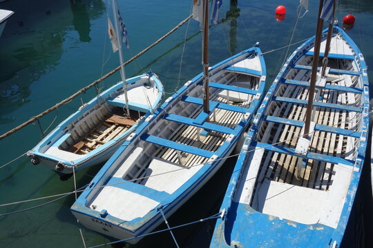 Close-up of old fishermen's boats painted white and blue on a sunny summer afternoon in Larnaca harbor, Cyprus