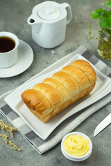 Roti Sobek or pull out Soft bread on ceramic white plate, tea time concept with a cup of tea. Bright mood photography concept. Close up view, isolated background. 
