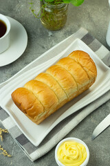 Roti Sobek or pull out Soft bread on ceramic white plate, tea time concept with a cup of tea. Bright mood photography concept. Close up view, isolated background. 