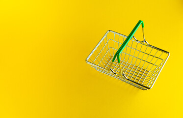 Shopping basket on a bright yellow background with an empty place for an inscription.