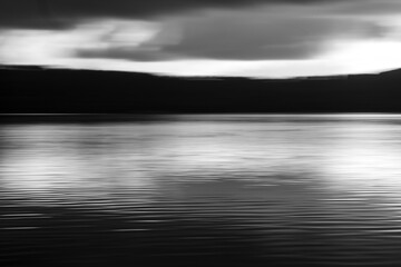 Fototapeta premium Vivid lights of the lake sunset with long exposure effect. Balck and white