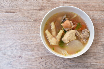 spicy chicken meat and foot in tom yum soup on bowl