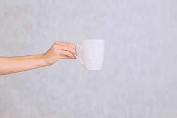White mug for coffee, tea in the girl's hand. On a white background.