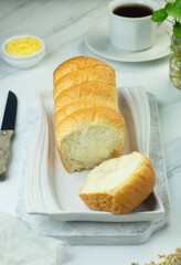 Roti Sobek or pull out Soft bread on ceramic white plate, tea time concept with a cup of tea....