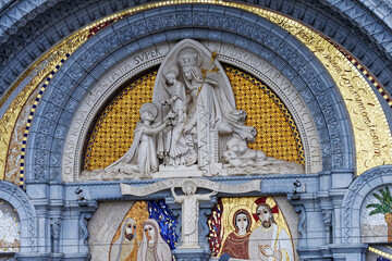 Detail of the sculptures above the entrance doors to the Sacred Basilica of Lourdes, important places of pilgrimage for the Catholic religion