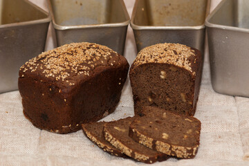Rye bread. Homemade baking. Dessert rye bread with raisins and walnuts in sourdough, sprinkled with sesame seeds and forms for baking bread