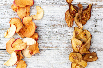 Border of a pile of dried pears and apples in slices on a white wooden background. Dried fruit chips. Healthy food