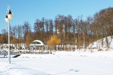 A fragment of the Feofania winter park in Kiev, a delightful view of the snow-covered lake and a beautiful gazebo.