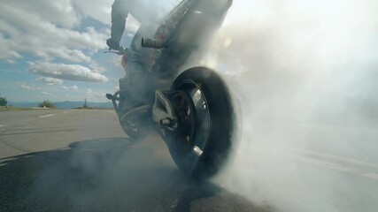 Close up of a motorcycle wheel burning rubber. Smoke and sparks from under the wheels of a sport motobike - Powered by Adobe