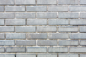 Gray brick wall background. Outdoor house facade texture. Dirty grunge brick wall. Gray vintage block structure. Old architecture background. Vintage weathered pattern.