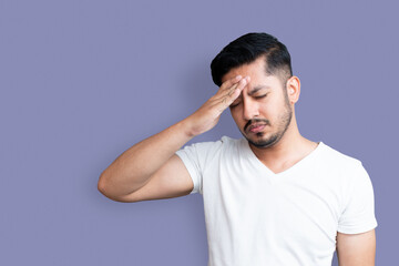 Close up photo of young age man perfect appearance one arm hand on forehead. Terrible pain in head, headache, closed wear casual white t-shirt isolated on background