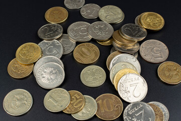 small metal coin heap on black background
