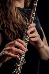 Close-up of the hands of a woman playing the flute. Musical concept. © fusssergei