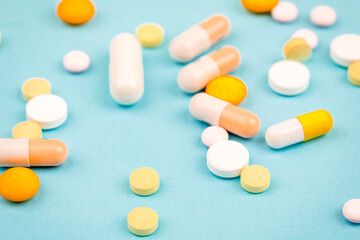A bunch of pills on a blue background. The concept of healthcare
