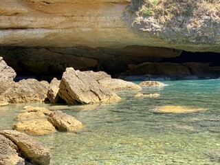 Sea cave in rocks, scenic Mediterranean coast. Turquoise blue sea waters. Solitude, silence, relax. Summertime.