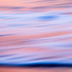 abstract landscape of sea. texture water, sky and sand in blurry motion in tropical sunset colors