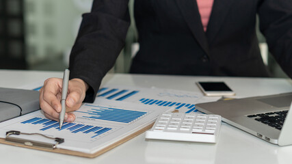 Businessmen analyze revenue charts and graphs with modern laptop computers and strategy ideas in the field of work.