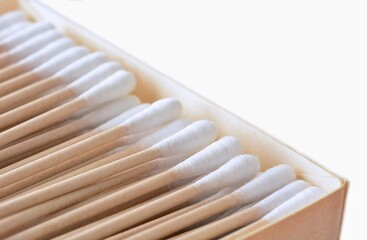 Box full of ecological paper cotton swabs on white background