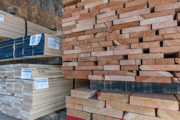 Stacks of lumber on a rack for sale to consumers at a retail hardwood lumber business.