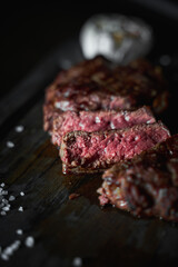Grilled and cut sirloin steak served on wooden board, medium cooked, closeup view