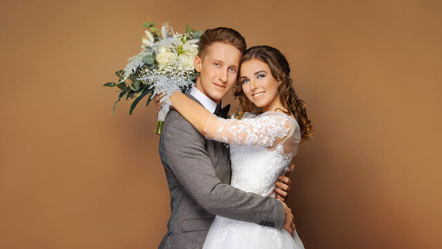 Wedding Couple, Beautiful Bride in White Dress with long train tail, Elegant Groom Kissing Romantic Studio Portrait