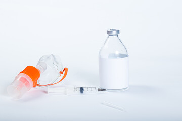 Treatment with nebulizer. Nebilizer mask and syringe with medicines on a white