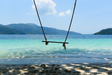 A wooden swing on the beach