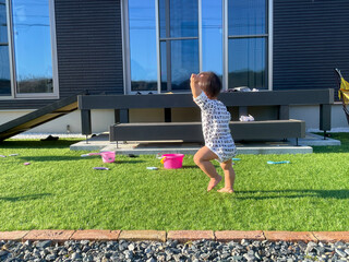 家の庭で遊ぶ男の子の赤ちゃん