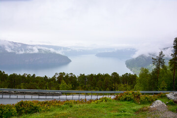 Picknickplatz Rastplatz mit Bank und Tisch über einem Fjord in Norwegen mit Nebel