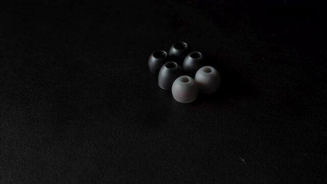 Set of silicone ear tips on black surface