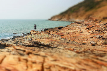 Rocks on the beach There is blue water, island and sky as background. Nature travel concept