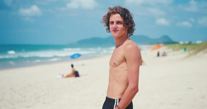 Young man's portrait. Portrait of the young Brazilian surfer on the beach. Hand held camera