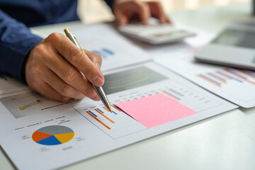 Male accountants or businessmen use a calculator and laptop to calculate investment results. And...