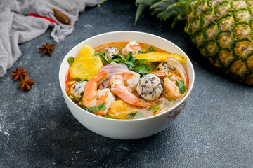 Vietnamese soup Pho with shrimp and squid and pineapple on bowl on dark concrete table