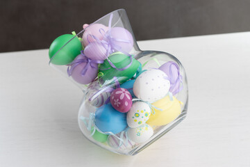 Glass vase filled with colorful Easter eggs 