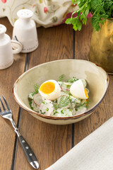 Summer salad with cucumbers, egg and radish in a bowl on the table