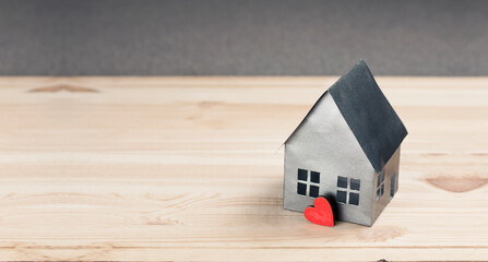 Obraz na płótnie Canvas Miniature paper model of the house. Concept of mortgage, rent, purchase, protection, construction of a house. On a wooden background