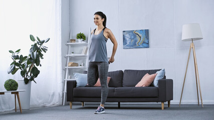 young woman in sportswear stretching at home