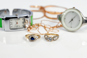 Glamorous girl accessories: wristwatches, gold rings and chain
