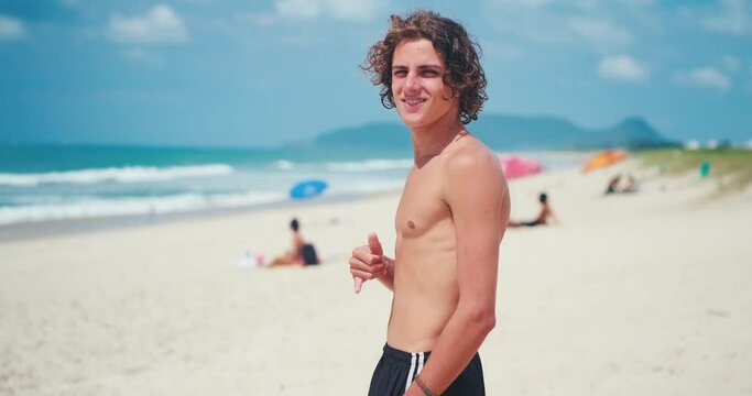 Young man's portrait. Portrait of the young Brazilian surfer on the beach. Hand held camera