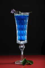 Blue cocktail with soda and gin, black background, selective