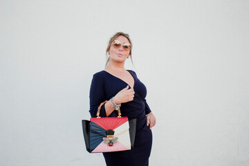 Mujer de mediana edad modelando en latinoamerica con pared blanca de fondo