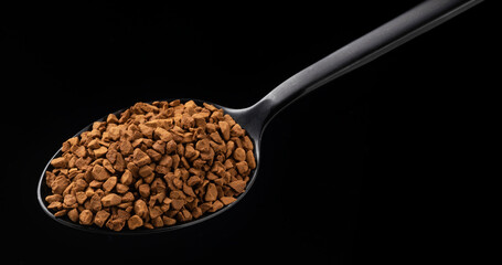 Instant granulated coffee on black background