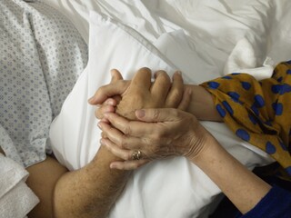 hands holding each other in the hospital room, accompaniment in difficult health moments