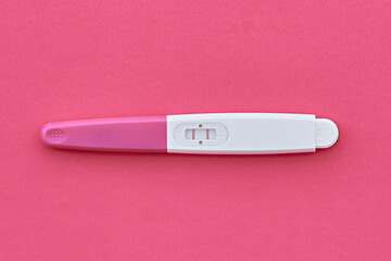 Positive two-strip pregnancy test on a pink background