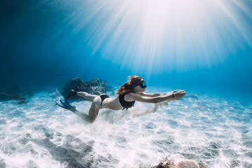 Free diver and white sand in hands over sandy sea. Freediving in tropical ocean