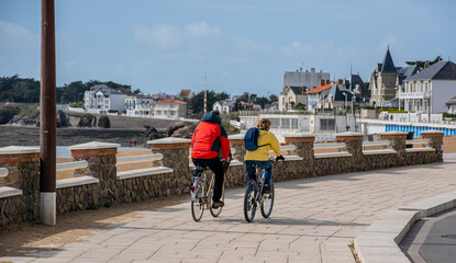 Vendée, FRANCE; March 14, 2021: Photo of a couple cycling on the Boisvinet cyclabe track in Saint Gilles Croix de Vie. 