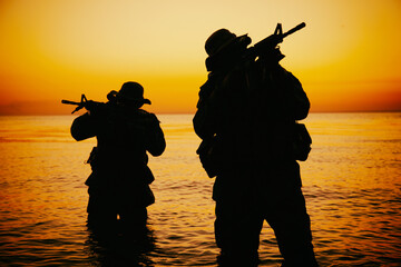 Two commando soldiers, army special operations fighters aiming assault rifles while coming out from...